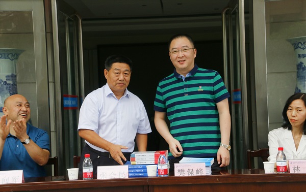 新乡市牧野区税务局党委书记、局长樊保峰向开云网页版_开云（中国党委书记张会民赠送税法知识书籍.jpg